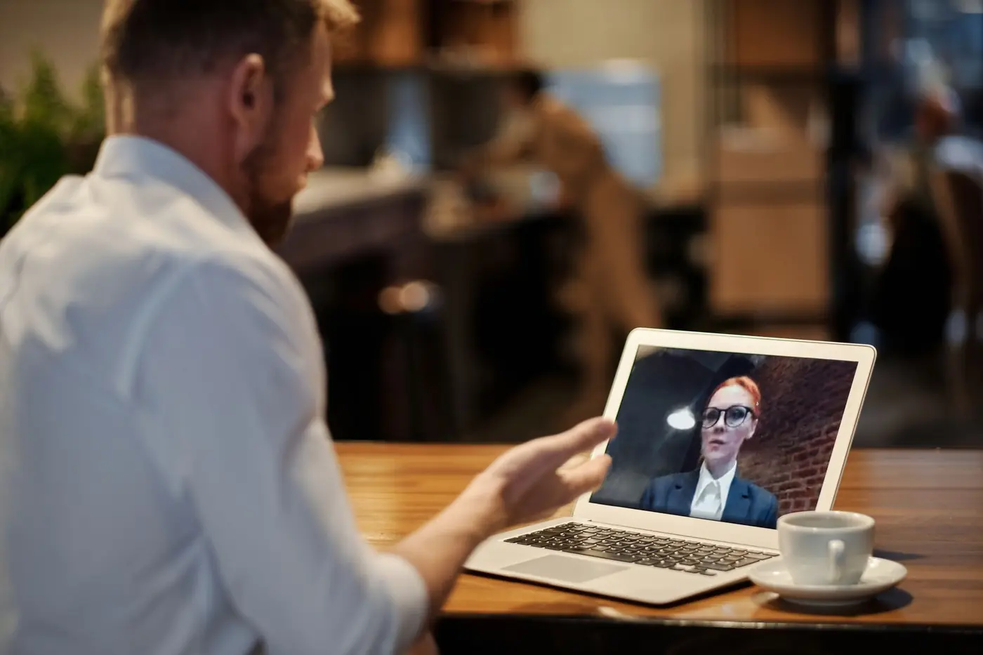 Una videochiamata di consulenza su un portatile, con una tazza di caffè sul tavolo